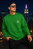 Man wearing a green sweatshirt and sunglasses, city skyline in the background.