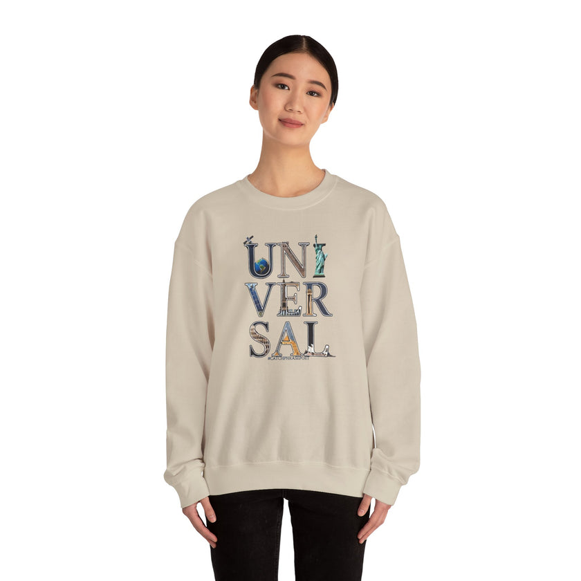 Woman wearing beige sweatshirt with 'UNIVERSAL' letters featuring landmark designs