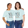 Two women smiling in light blue 