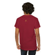 Person wearing a red t-shirt with a small gold emblem on the upper back, casual style