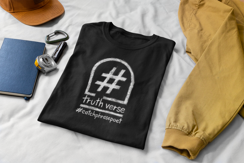 Black graphic t-shirt with 'truth verse' and hashtag, creative poetry clothing on bed