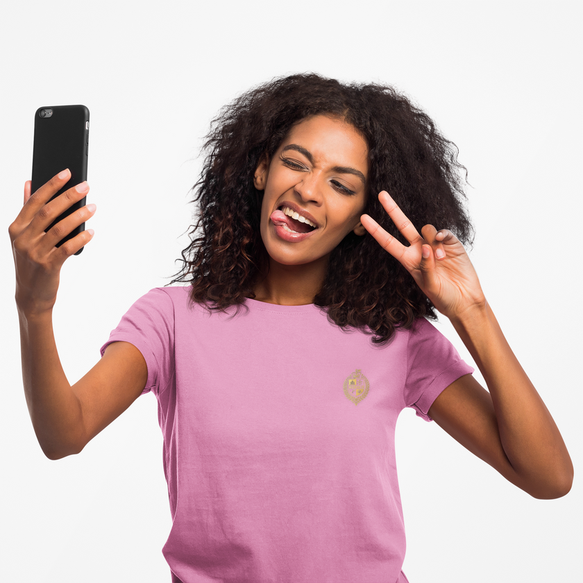 Woman in pink t-shirt taking selfie, making peace sign, casual creative style