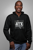 Smiling man wearing a black zip hoodie with ATX Texas graphic and blue jeans