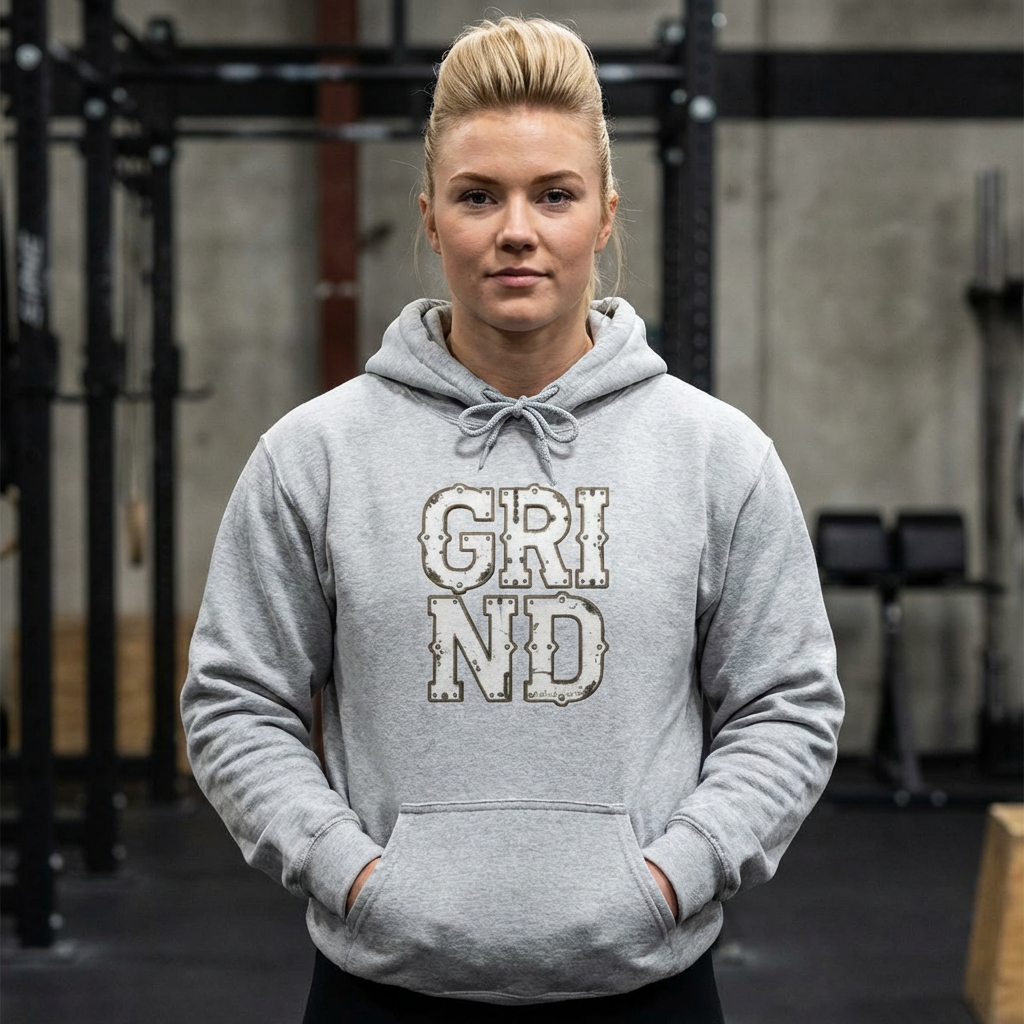 Person wearing a gray hoodie with 'GRIND' text in a gym setting
