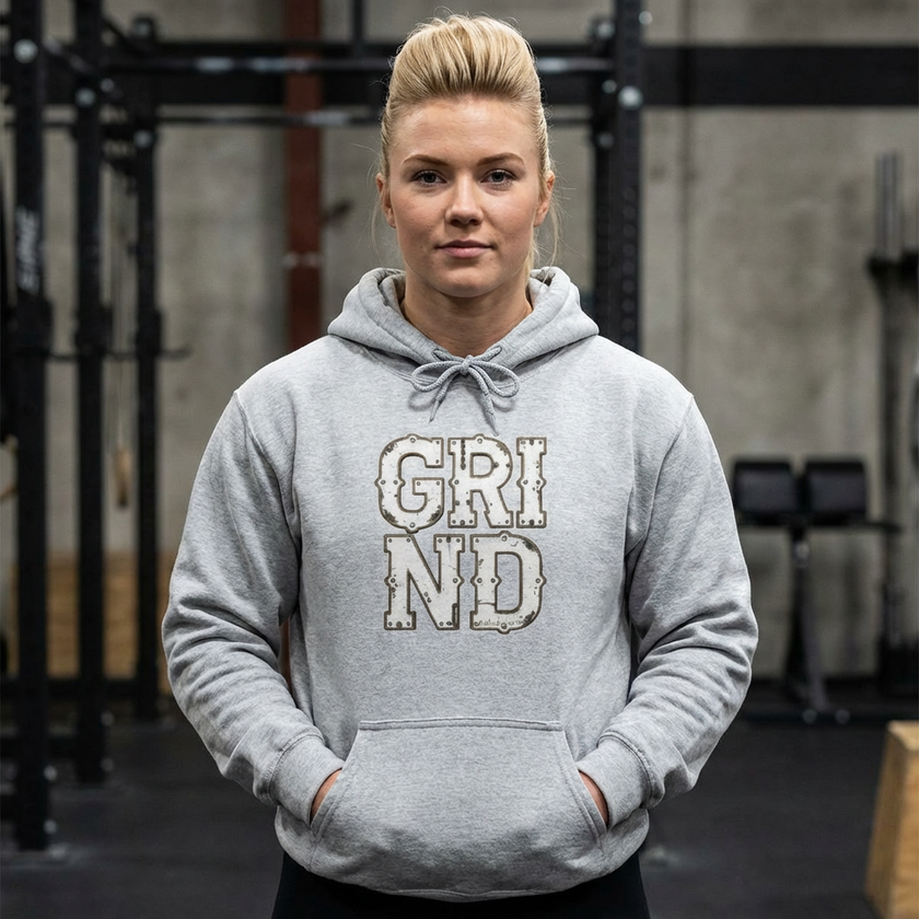 Person wearing a gray hoodie with 'GRIND' text in a gym setting
