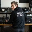 Person wearing a black hoodie with text in a music studio