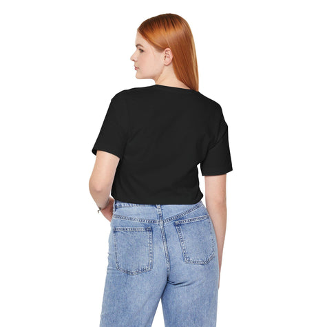 Woman in black t-shirt and light blue jeans, viewed from the back, on white background