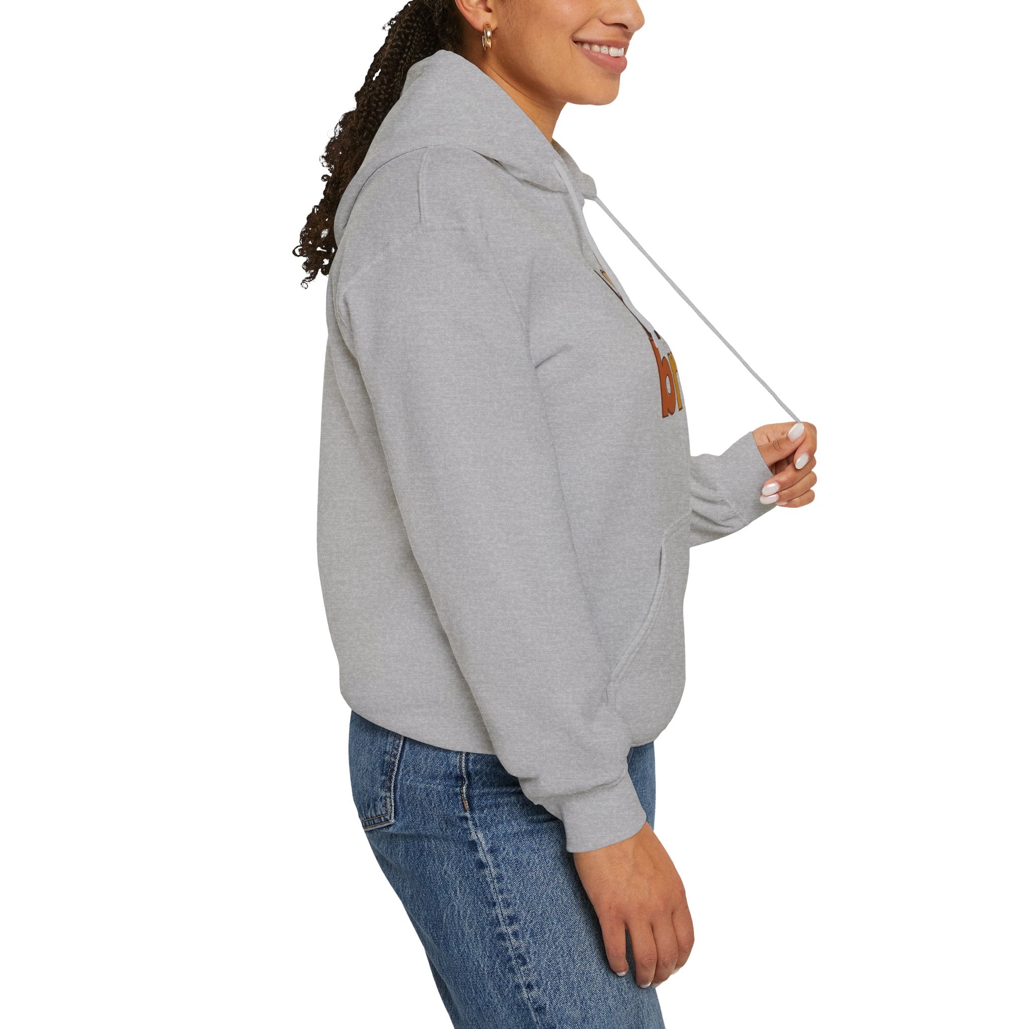 Woman wearing a light gray hoodie and blue jeans, side view, studio background