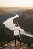 White t-shirt with 'Be Still' text in gold on a white background