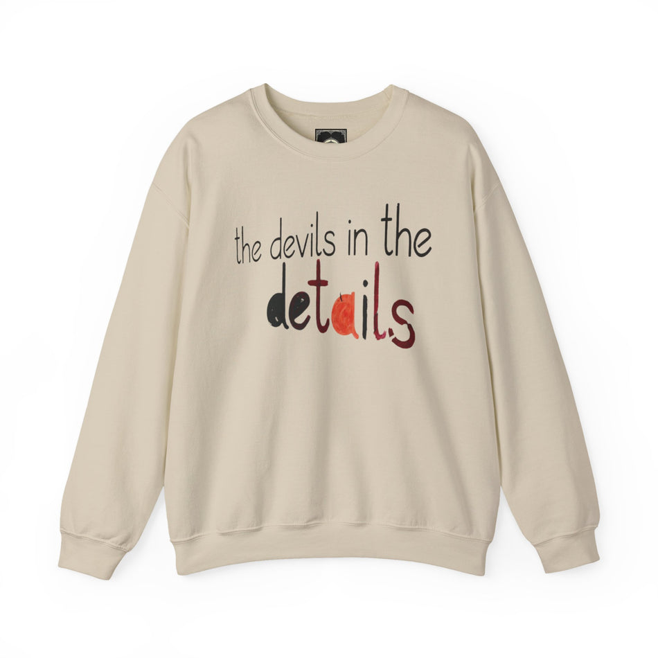 Beige crewneck sweatshirt with 'the devils in the details' text graphic on front