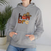 Person wearing gray hoodie with 'hombre' text and sombrero graphic, casual clothing style