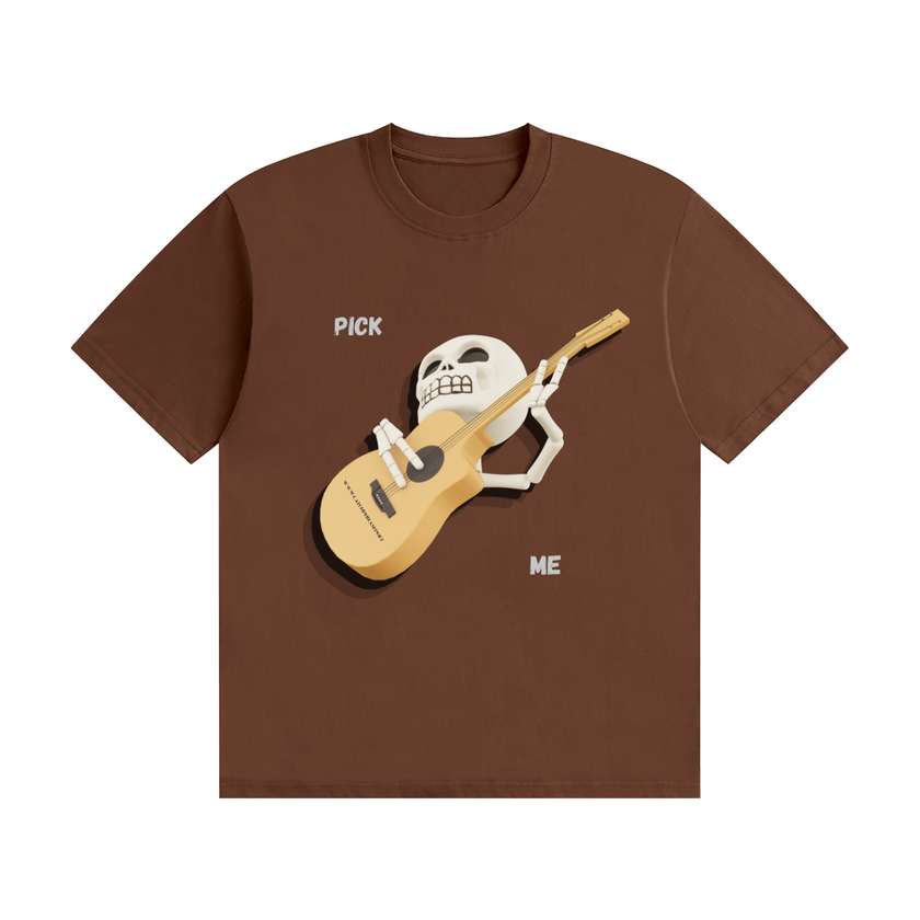 Tattooed musician in a studio wearing the brown Pick Me skeleton guitar tee while restringing an acoustic guitar — Catch Phrase Poet