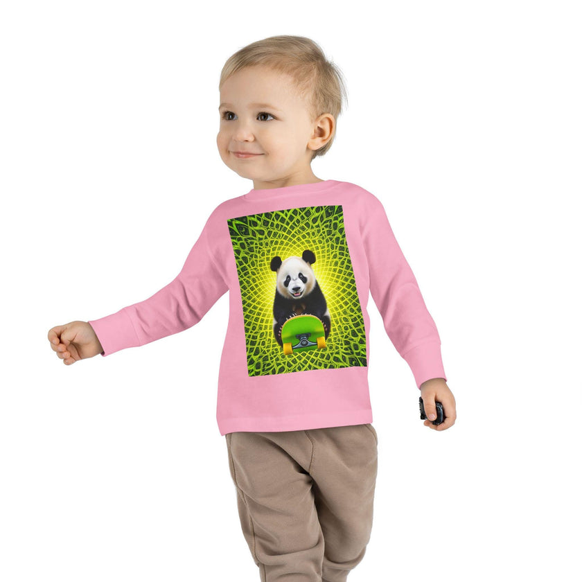 Toddler in pink sweatshirt with panda and skateboard graphic, green geometric background