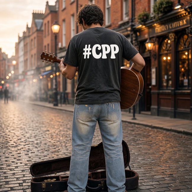Young man busking on the streets of Dublin in sun-fade raw hem denim jeans, CPP logo on the back of his tee — Catch Phrase Poet
