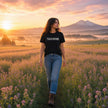 Woman at sunrise in an alfalfa field in Central Oregon wearing the Touch Grass black t-shirt
