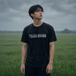 Man running through grass wearing the Touch Grass black t-shirt